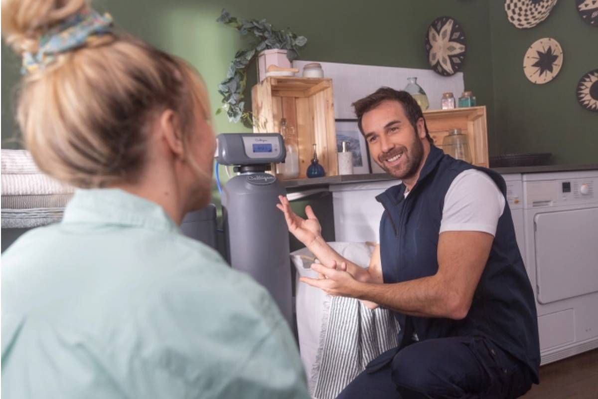 Plombier professionnel installant un adoucisseur d'eau dans une maison en Haute-Savoie
